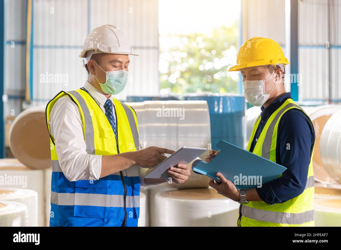 Ingeniero asiático capataz lista de comprobación de trabajo con el trabajador del personal en la fábrica de almacén Foto de stock