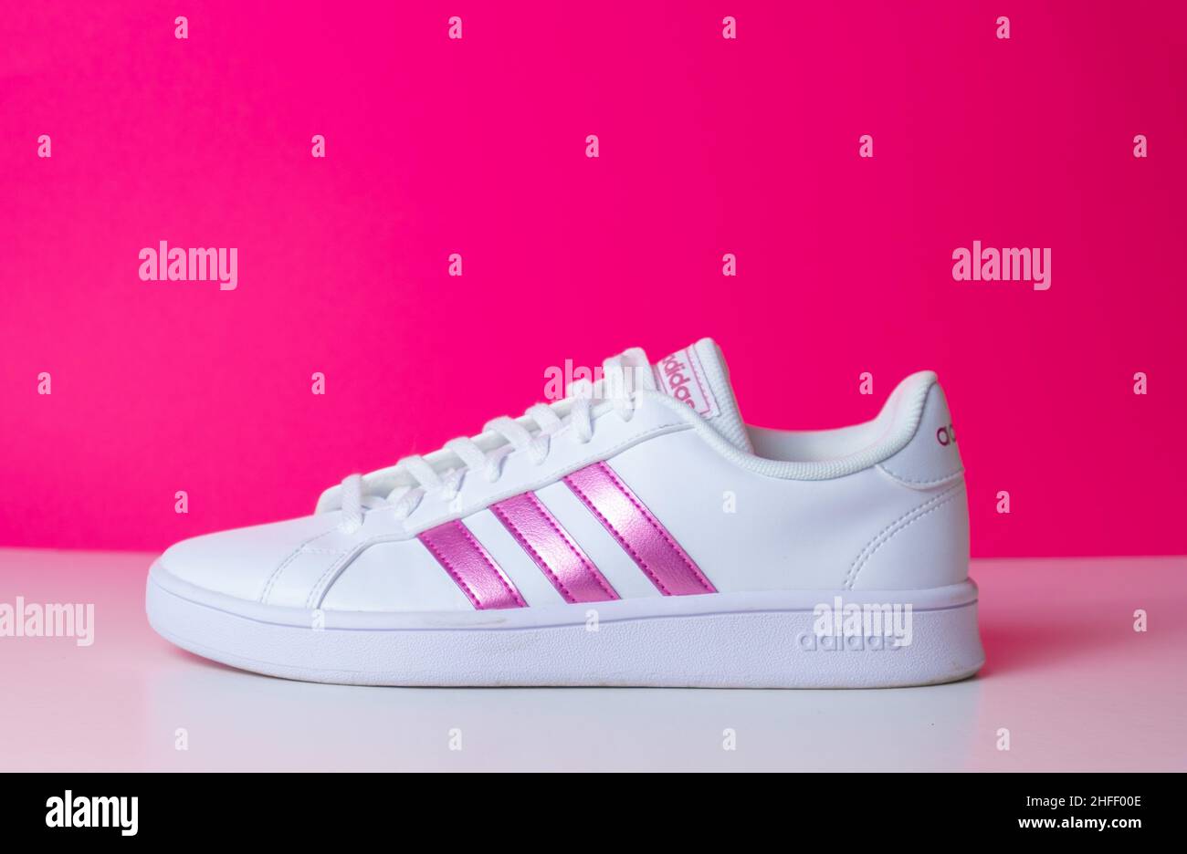 Badajoz, España, 01, 16,2022. Zapatillas de lona de color rosa adidas con  vista lateral del calzado en el suelo con enfoque suave y espacio de copia  Fotografía de stock - Alamy