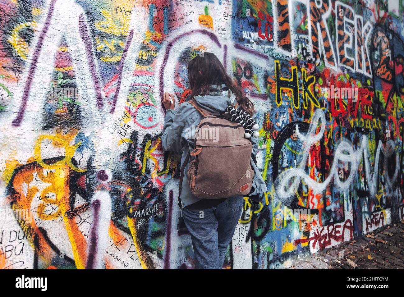 Chica escribe en el famoso Muro de John Lennon en praga Foto de stock