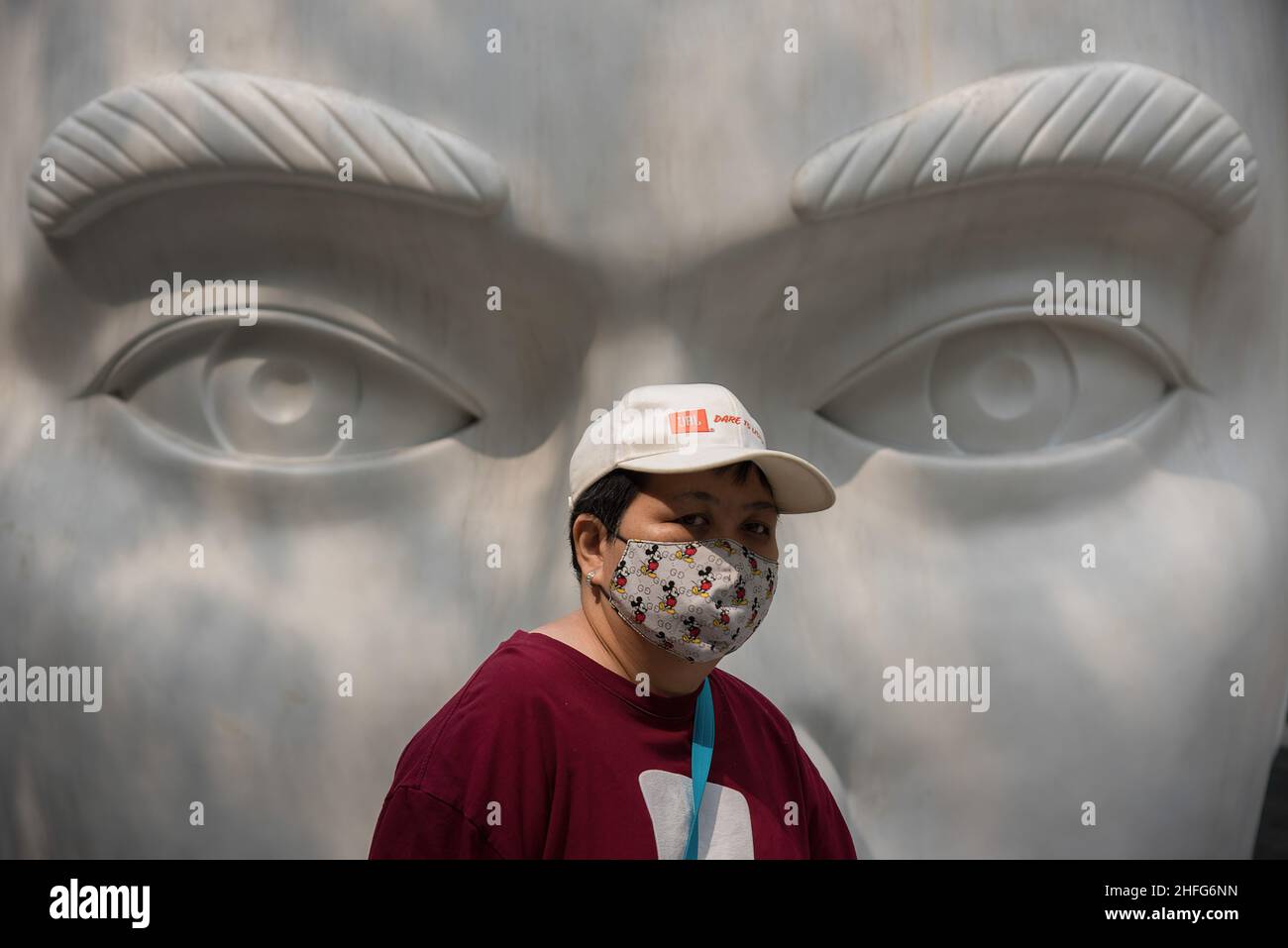 Bangkok, Tailandia. 16th de Ene de 2022. Una mujer que lleva una máscara facial como medida preventiva contra la propagación del covid-19 camina por una escultura fuera del Mundo Central, el centro comercial de Bangkok. (Foto de Peerapon Boonyakiat/SOPA Images/Sipa USA) Crédito: SIPA USA/Alamy Live News Foto de stock