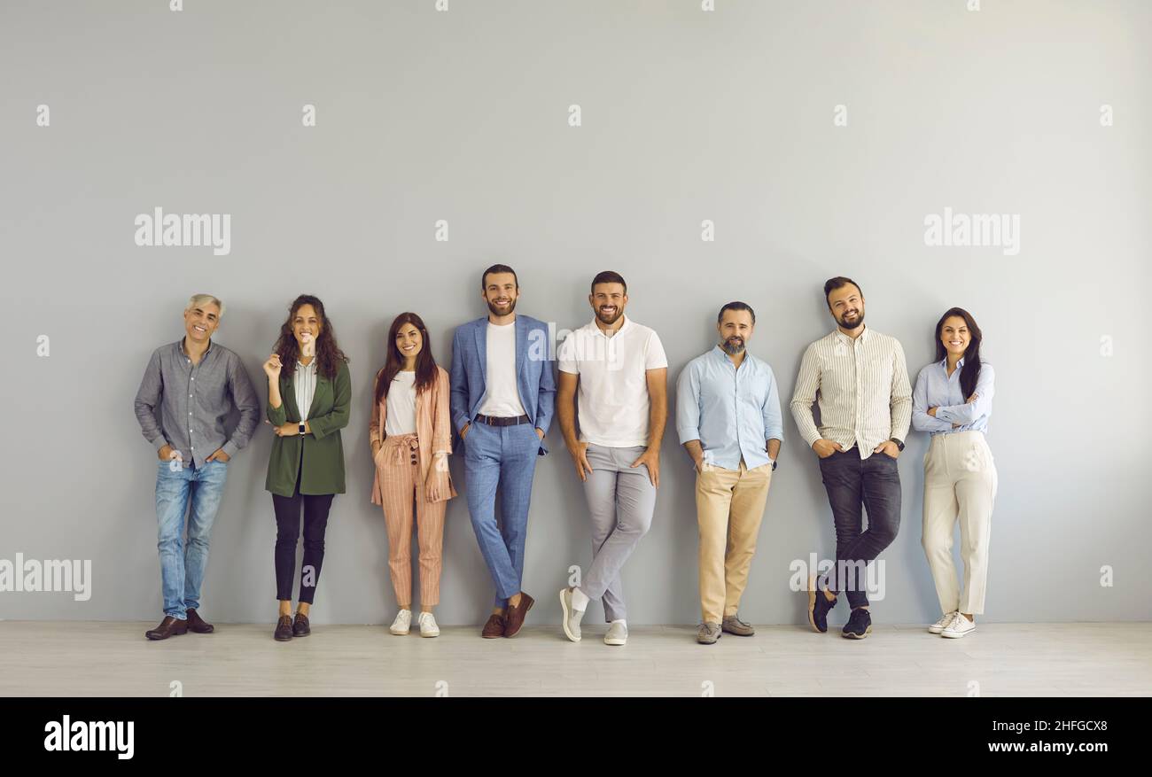 Retrato de grupo de gente de negocios feliz en ropa elegante e informal de pie en el estudio Foto de stock