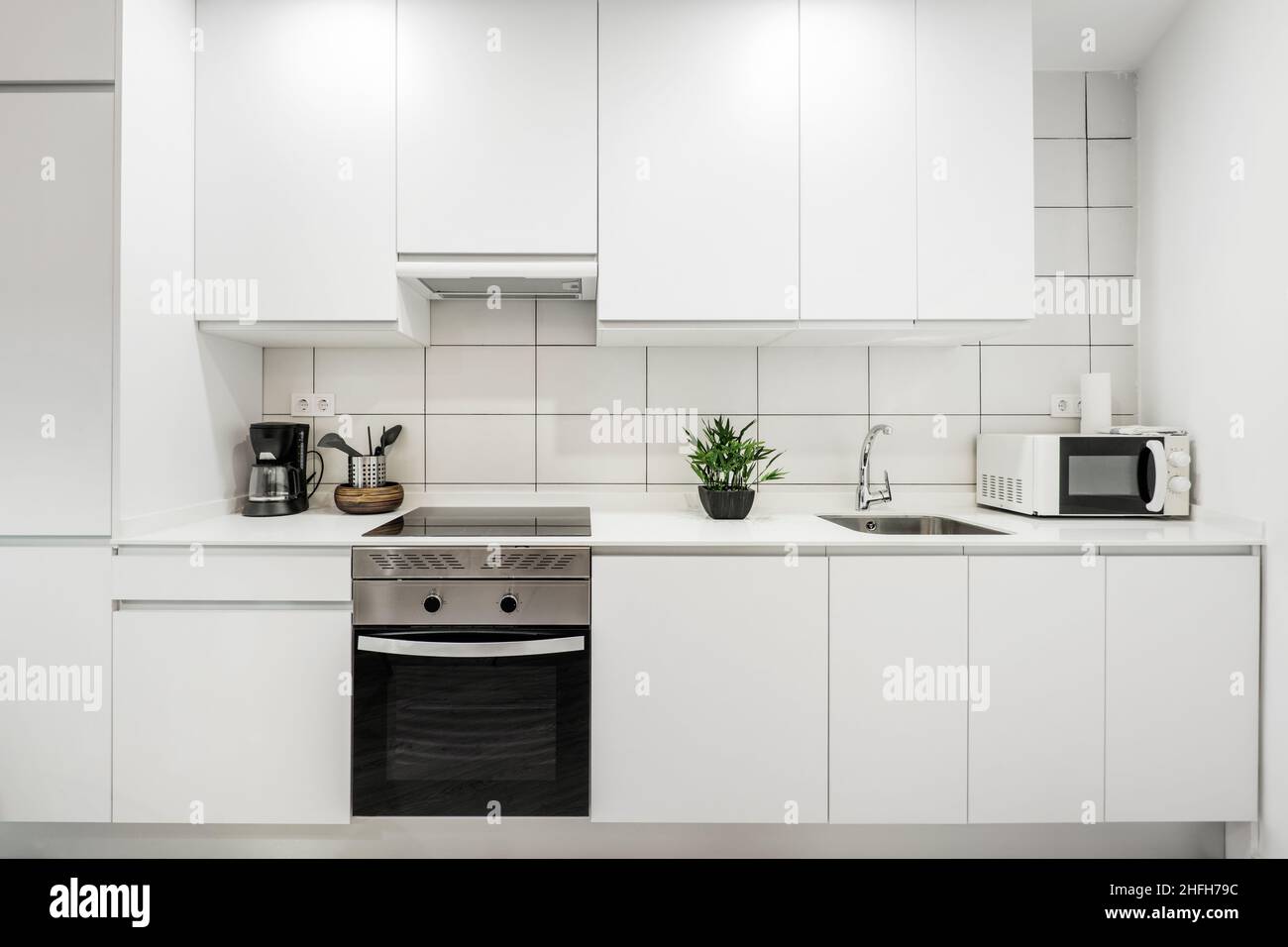 pared cubierta con muebles de cocina blancos con encimera de piedra  plateada blanca y azulejos rectangulares Fotografía de stock - Alamy