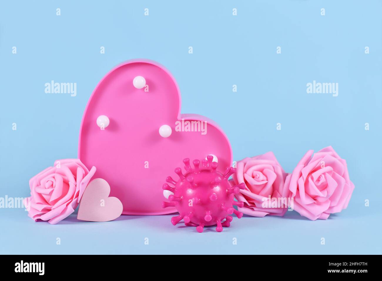 Día de San Valentín durante el concepto de pandemia de Corona con modelo de virus, rosas y corazones sobre fondo azul con espacio de copia Foto de stock