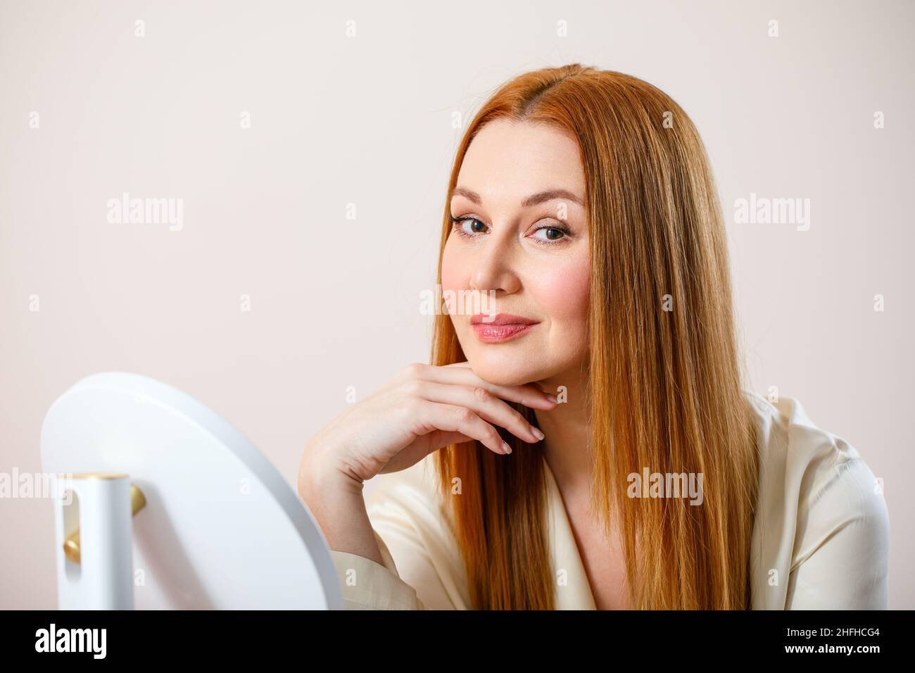 Retrato de una mujer adulta. La mujer mira la cámara y sonríe. Foto de stock
