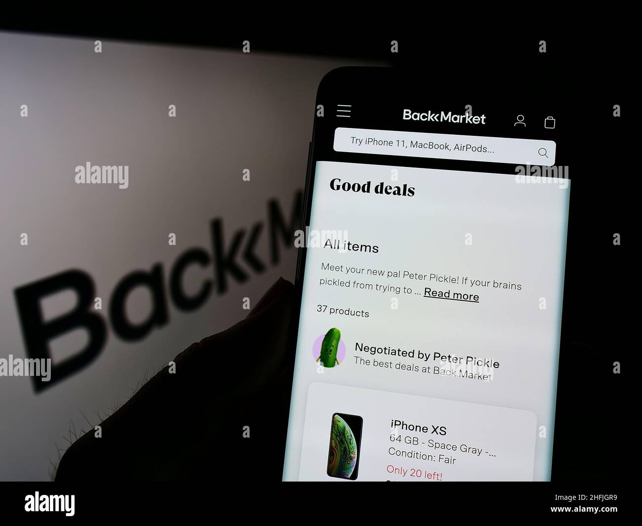 Persona que sostiene celular con sitio web de la empresa francesa de