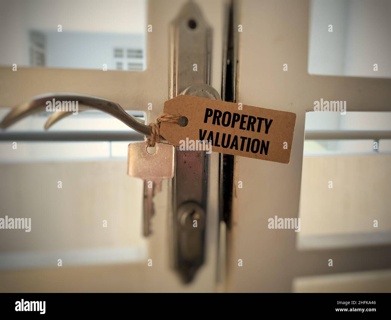 Etiqueta de valoración de la propiedad sobre etiqueta de papel marrón con fondo de llave y puerta. Concepto de propiedad. Foto de stock