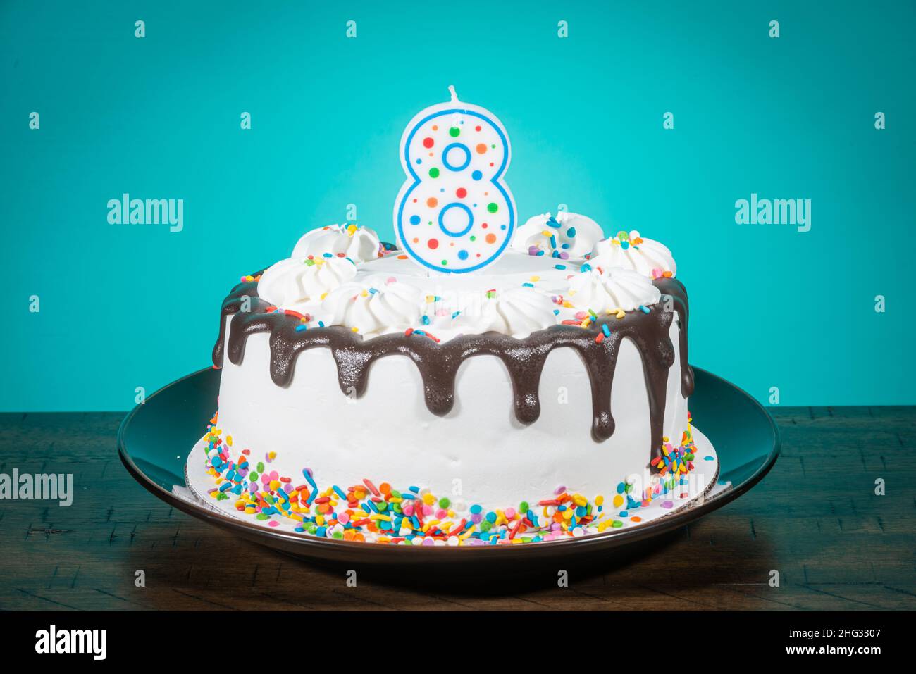 Tortas de cumpleaños con bengala encendida y fondo con banderines rojos  Stock Photo