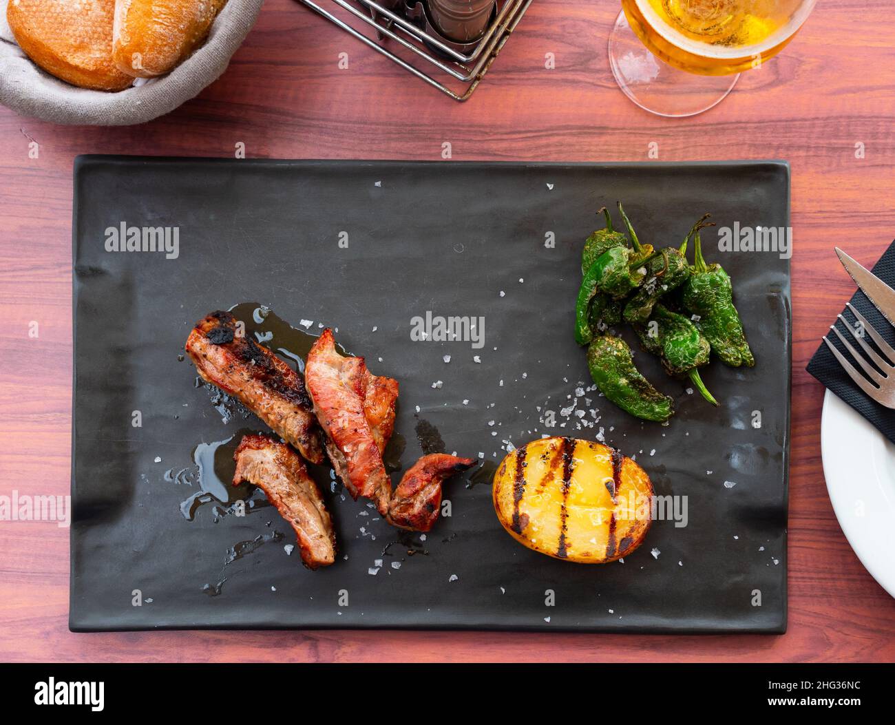 El plato español popular es el lagarto ibérico a la parrilla con patatas y pimienta Fotografía de stock - Alamy