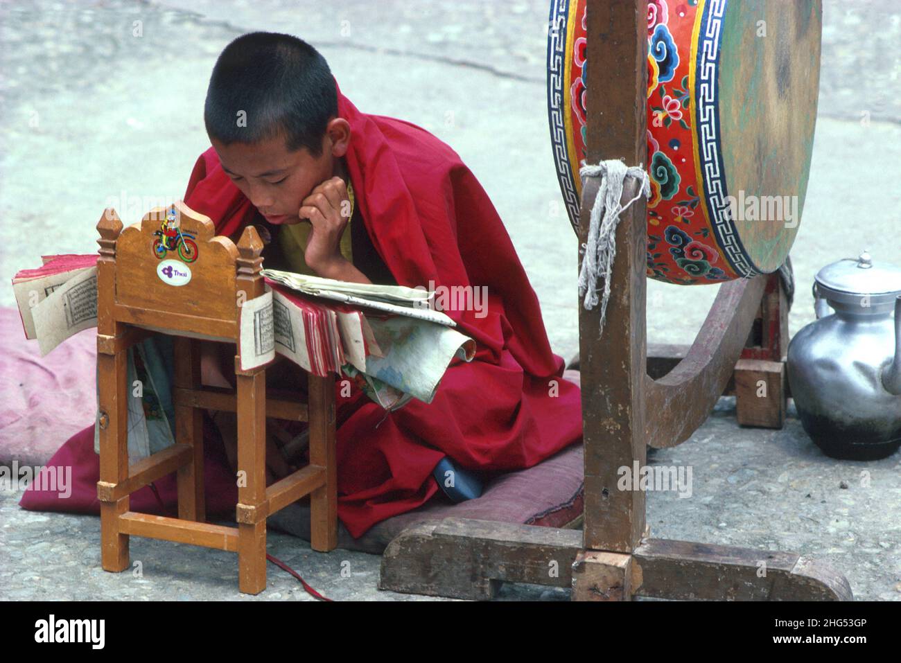 Joven monje refugiado tibetano leyendo y recitando escrituras budistas en un monasterio cerca de Gangtok. Sikkim, N. India Foto de stock