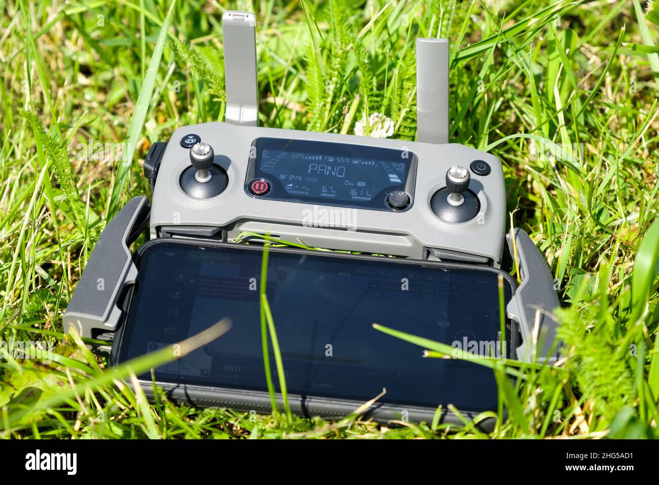 El controlador de la consola de drone con el teléfono móvil está tumbado en la hierba. Fotografía aérea de la naturaleza. Enero de 2022, Poprad, Eslovaquia Foto de stock