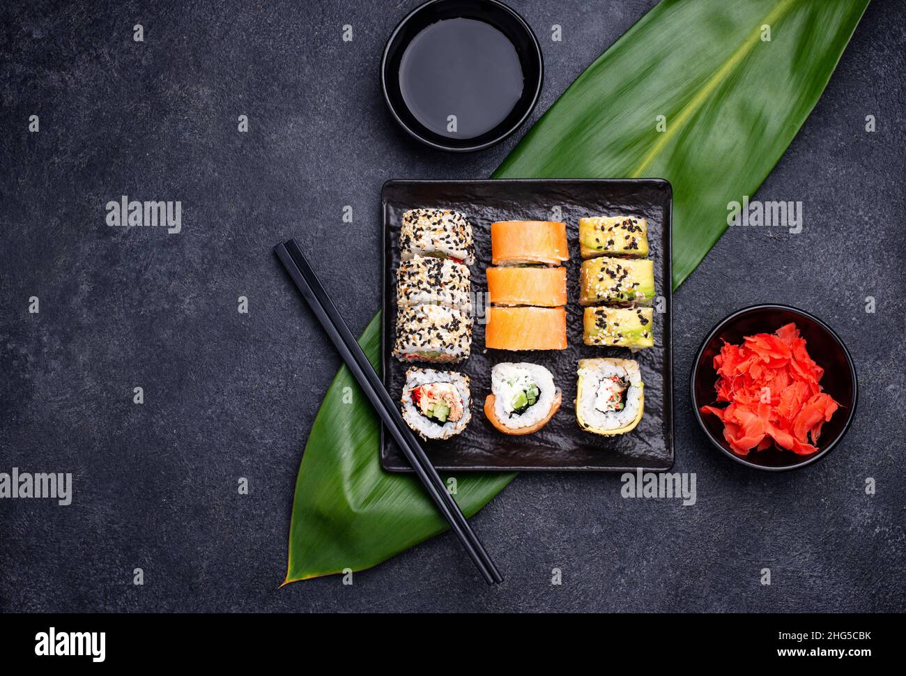 Rollitos de sushi japonés tradicional sobre fondo oscuro Foto de stock