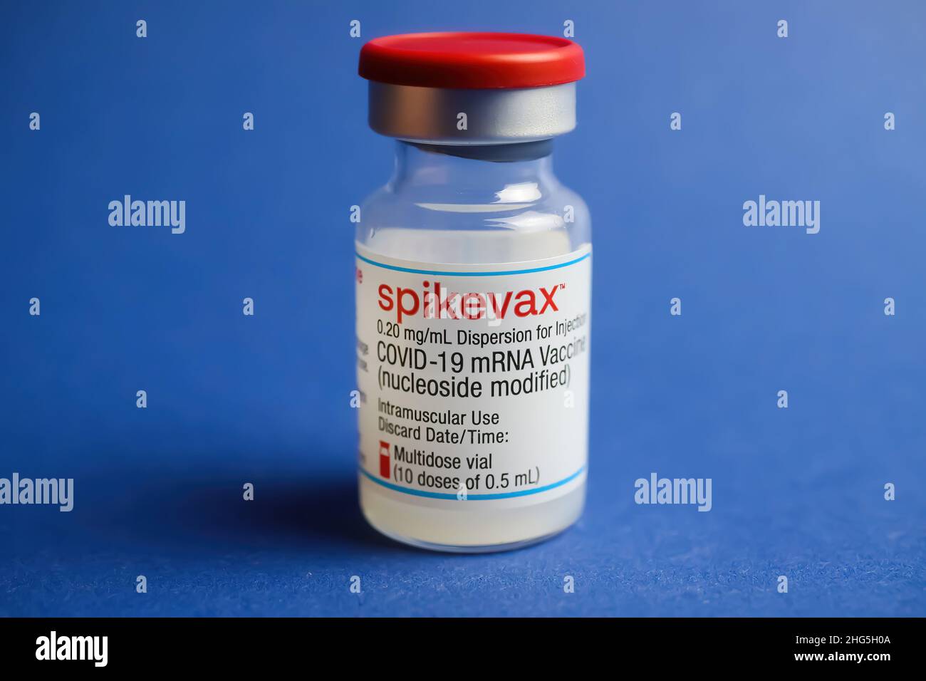 Viersen, Alemania - Enero 9. 2022: Cierre de un vial aislado de suero de vacunación con ARNm Moderna Spikevax , fondo azul Foto de stock