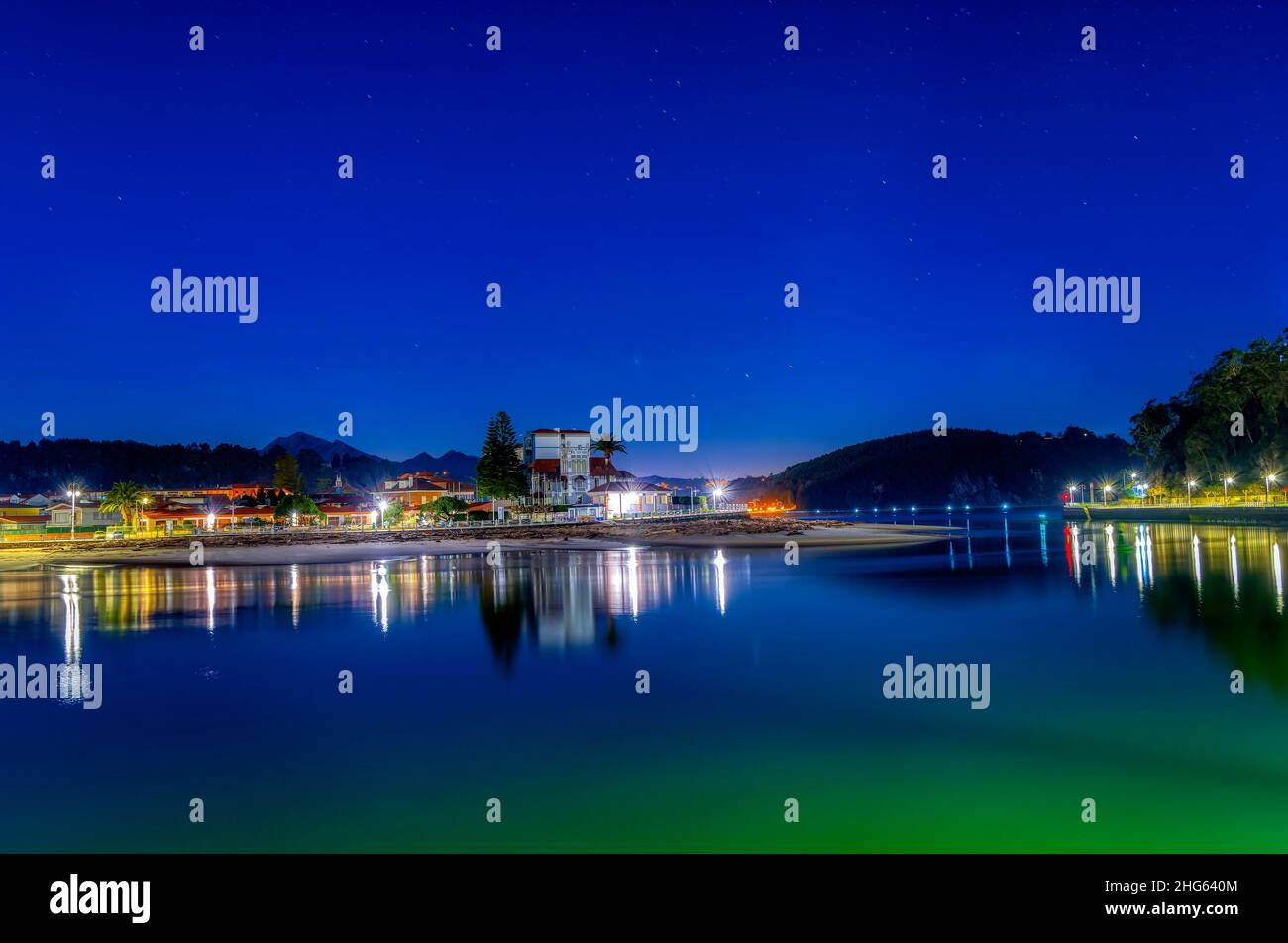 Entrada al puerto de Ribadesella, con la playa de Santa Marina al fondo, en una noche estrellada. Asturias, España. Foto de stock