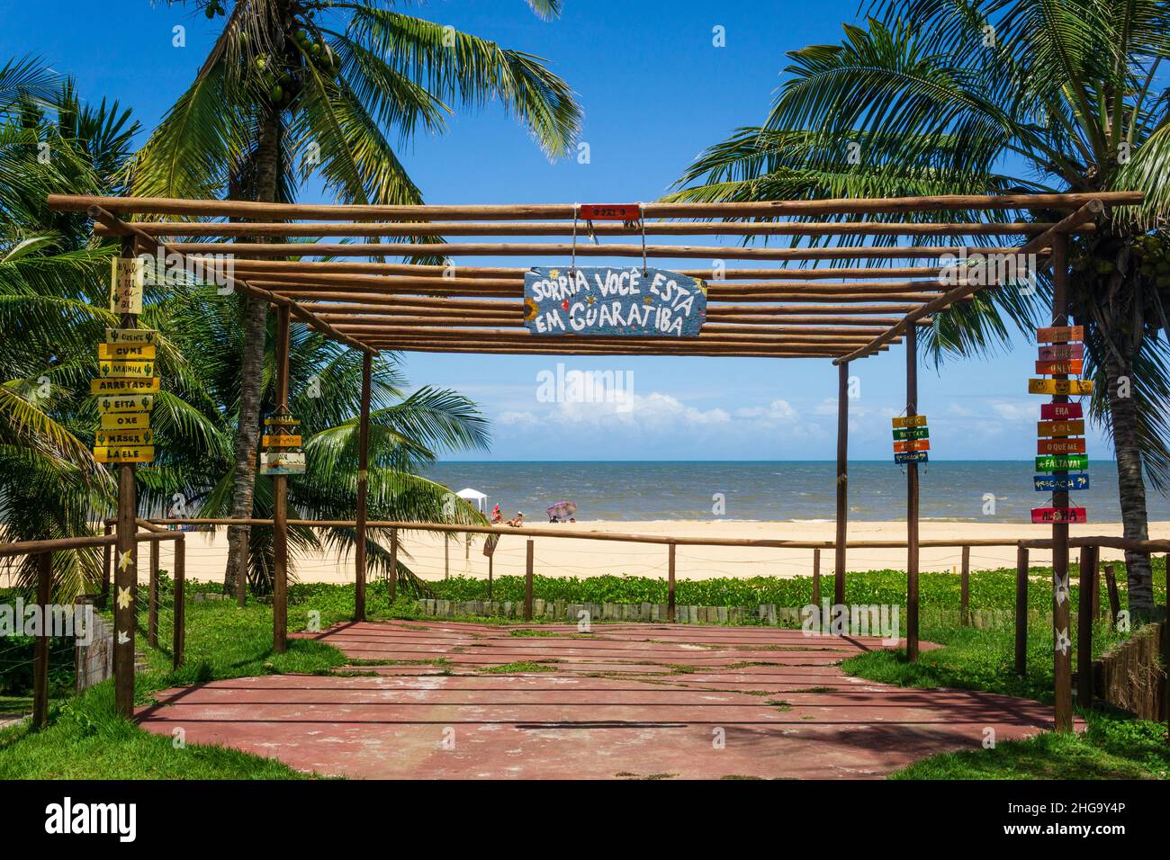 Sorria você está em Guaratiba, signo de madera pintado a mano para dar la bienvenida a los visitantes de la playa de Guaratiba, Prado, Bahia, Brasil. Foto de stock