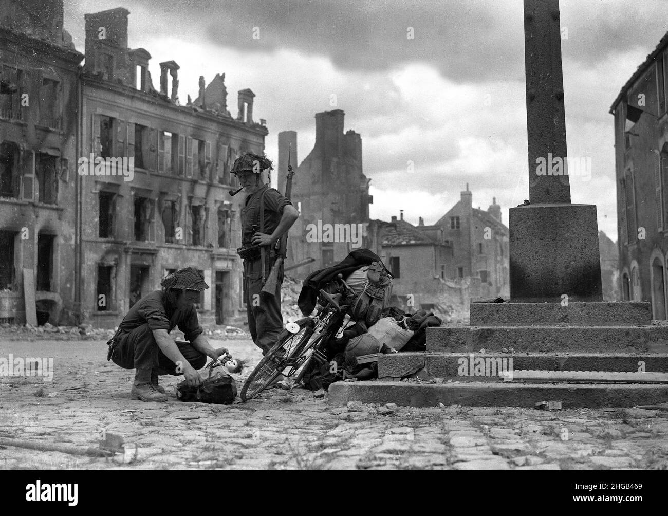 Norte de Francia Guerra Mundial Dos 1944 soldados británicos mirando una muñeca infantil encontrados con una bicicleta de civiles tratando de escapar. ARCHIVOS MÁS GRANDES DISPONIBLES BAJO PETICIÓN Foto de stock