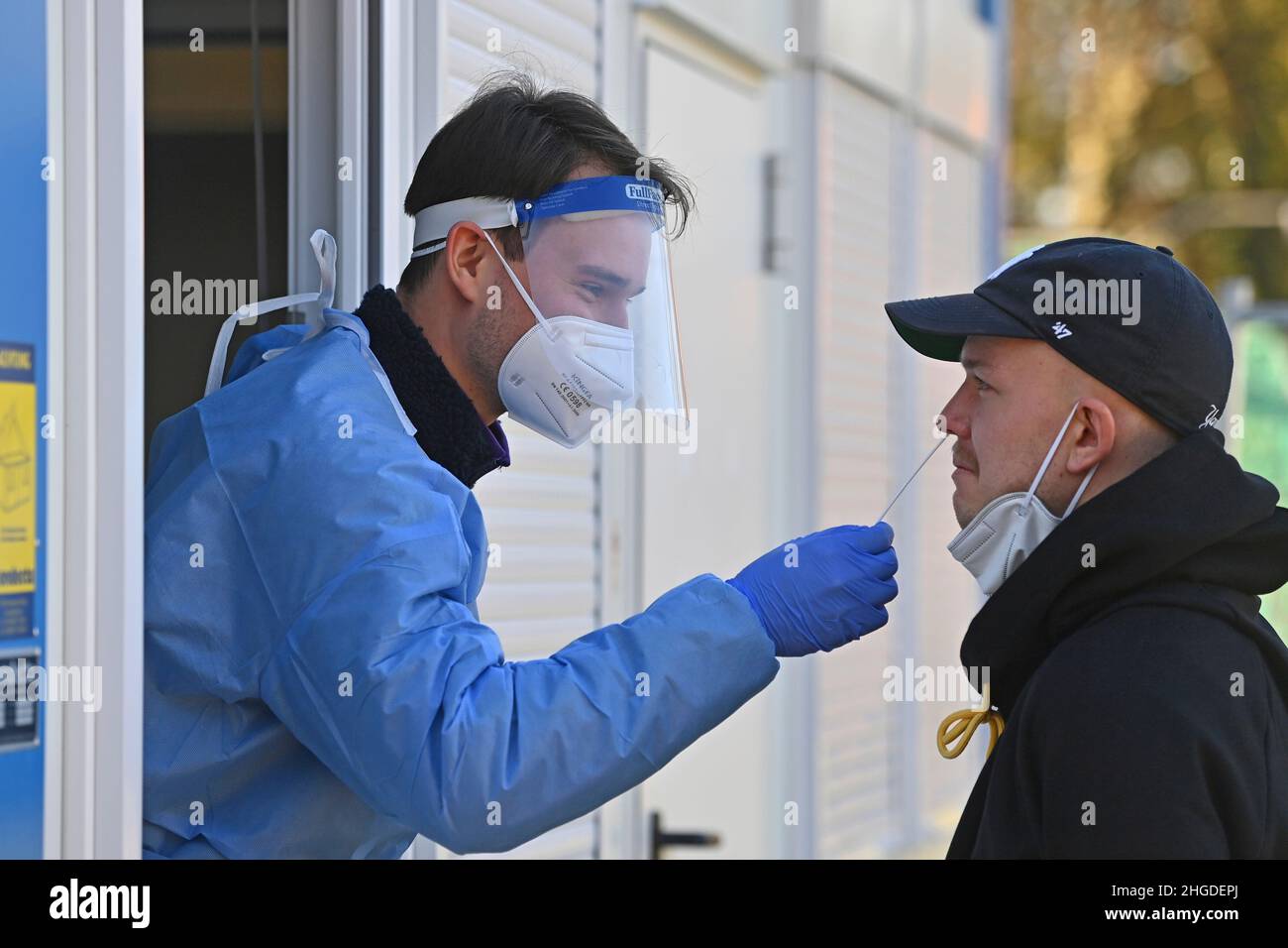 Munich, Alemania. 19th de Ene de 2022. Imagen temática Variante de Covid-19 de Omicn. Un probador toma un hisopo nasal, prueba rápida de Corona para la variante de Omicra. Estación de pruebas Corona, estación de pruebas, centro de pruebas, centro de pruebas corona. Prueba rápida Prueba rápida de antígeno. El personal médico lleva trajes de protección y protectores faciales, máscaras faciales completas, máscaras faciales y toma hisopos de las personas. Crédito: dpa/Alamy Live News Foto de stock