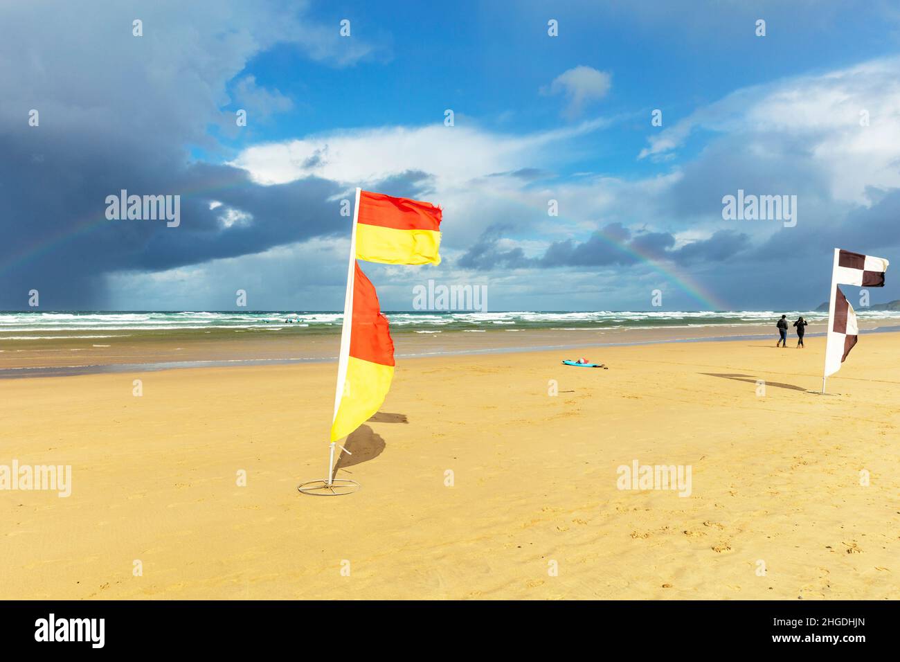 Las zonas de baño designadas están marcadas en las playas con banderas rojas y amarillas de la RNLI. Estas banderas indican las áreas patrulladas por socorristas. En desig Foto de stock