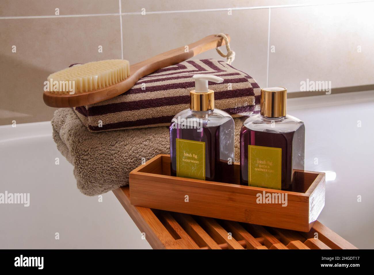 Tendedero de madera con cepillo, toallas, lavado de manos y gel de baño en un baño moderno, estilo de vida Foto de stock