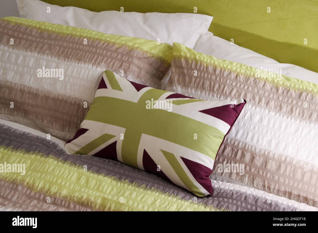 Cojín sobre una cama en estilo bandera de la bandera de la unión, en colores verde y blanco. Foto de stock