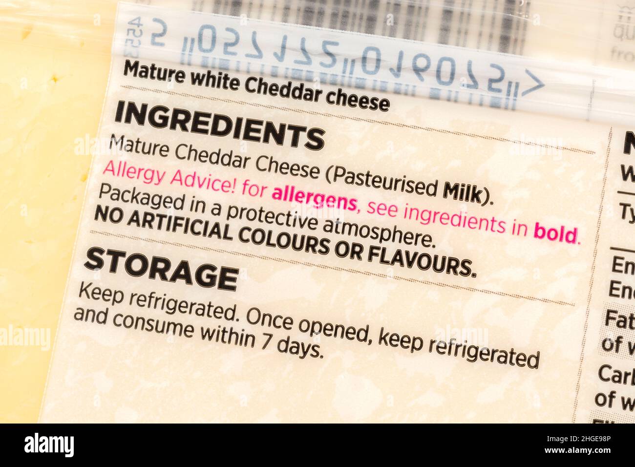 Primer plano de los ingredientes de la etiqueta de queso cheddar de marca propia de ASDA con advertencia de alérgenos de tipo rojo. Para alergias a alimentos, y posiblemente dieta sin lácteos. Foto de stock