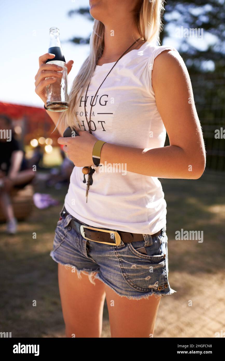 Preparado para la fiesta. Foto recortada de una mujer joven que llevaba pantalones  cortos sosteniendo una bebida en un festival Fotografía de stock - Alamy