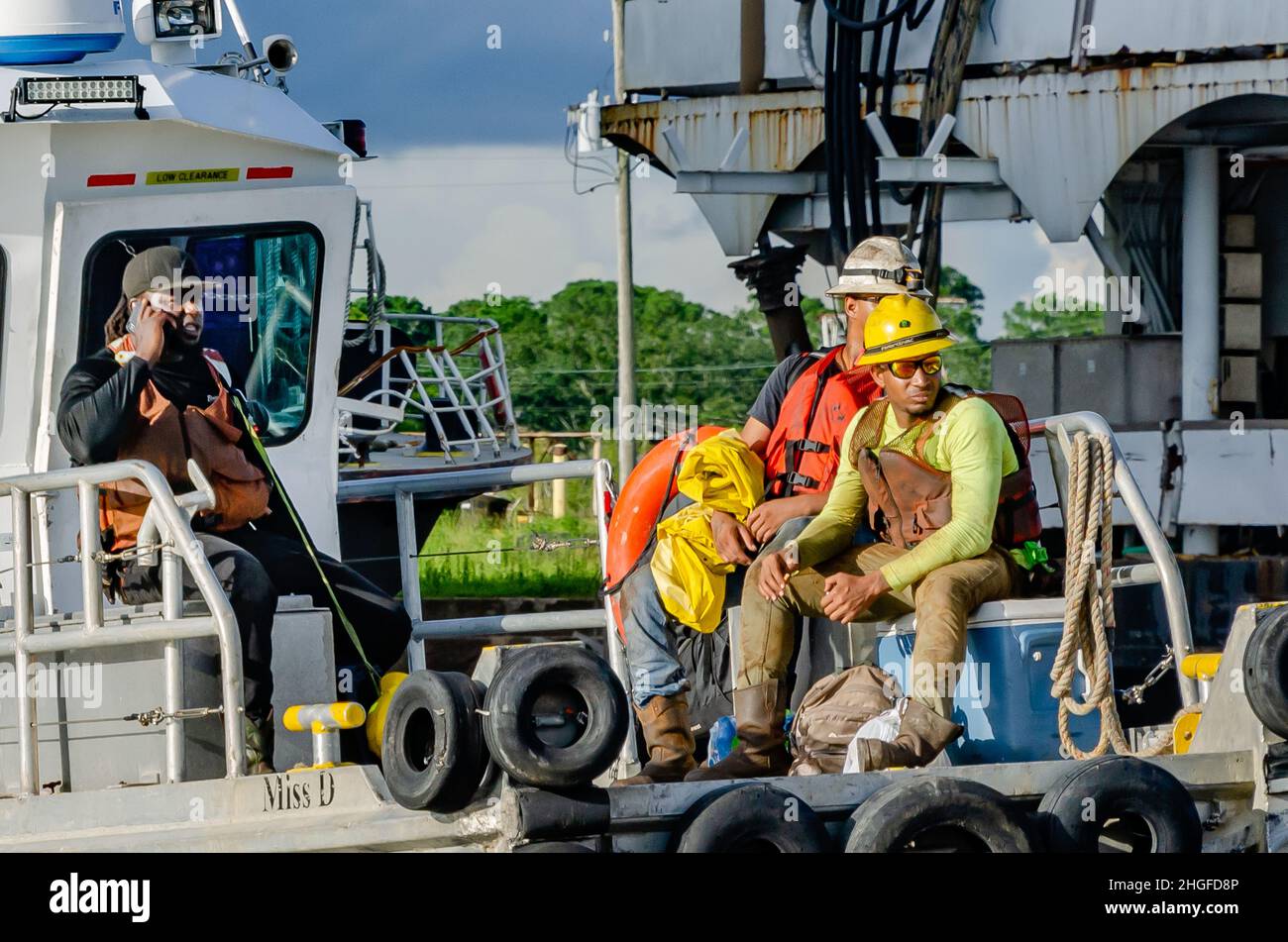 Los trabajadores se reúnen cuando el remolcador Miss D llega a tierra, el 1 de julio de 2021, en