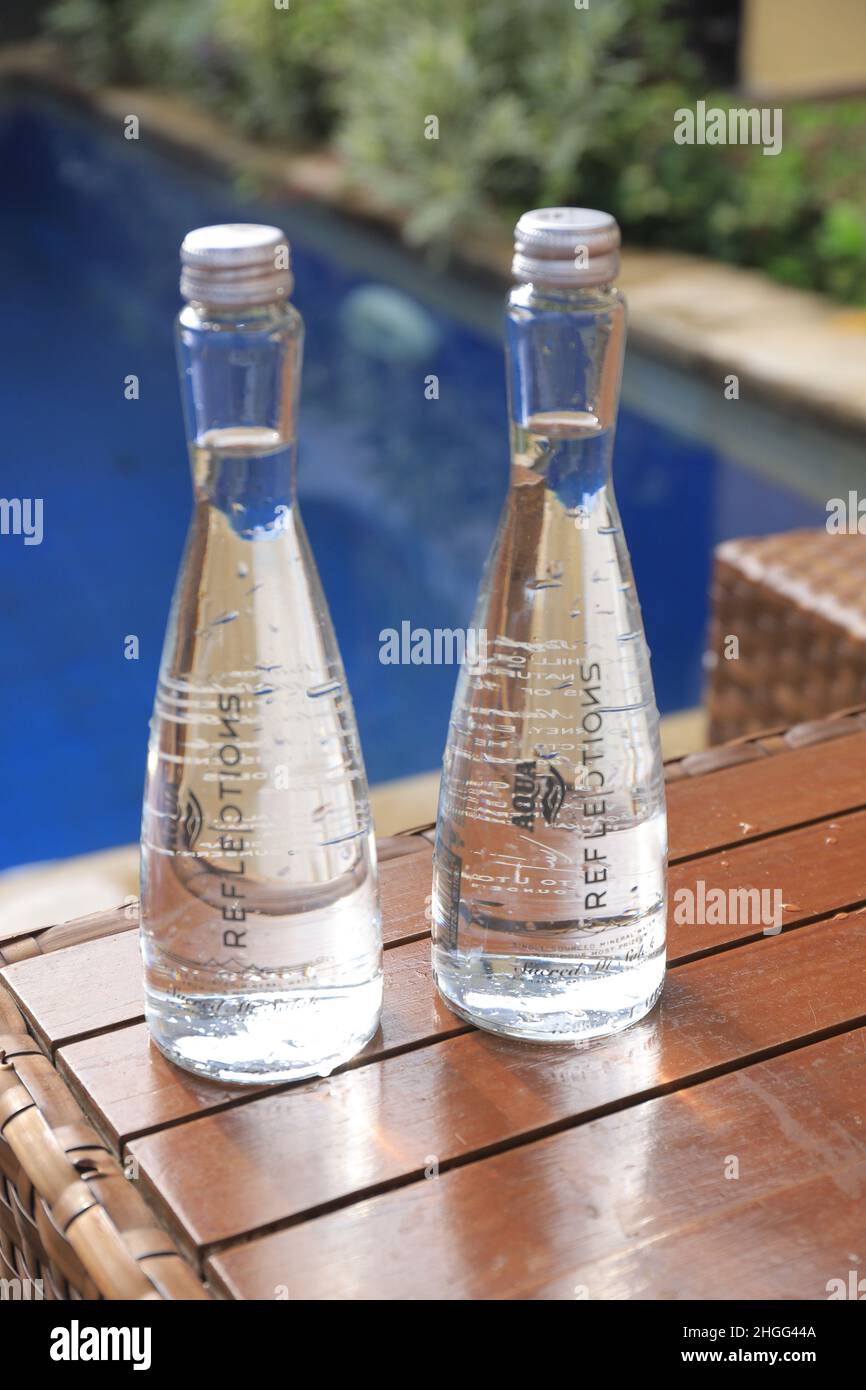 BANYUWANGI, INDONESIA - 19 de enero de 2022: Agua mineral de marca Aqua se coloca junto a la piscina Foto de stock
