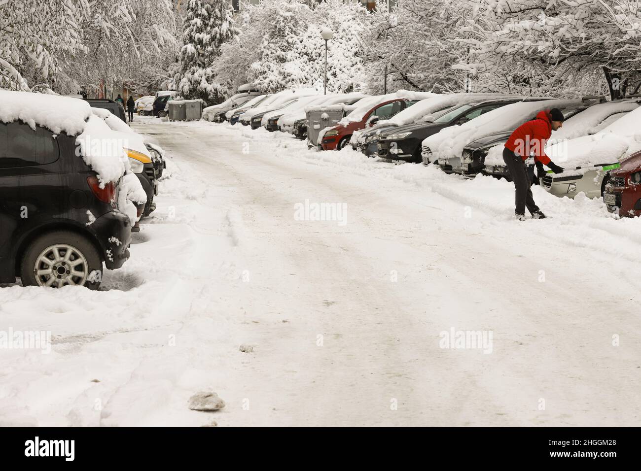 La gente limpia la nieve de los coches después de nevar en Sofía, Bulgaria el 21 de enero de 2022 Foto de stock