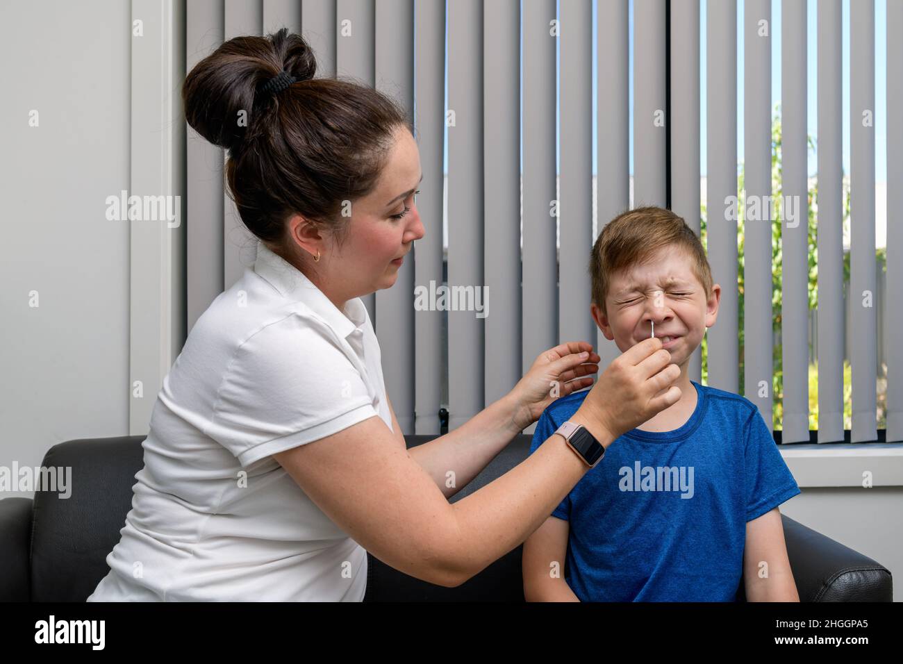 Madre que hace la prueba rápida de antígeno COVID-19 para su hijo Foto de stock