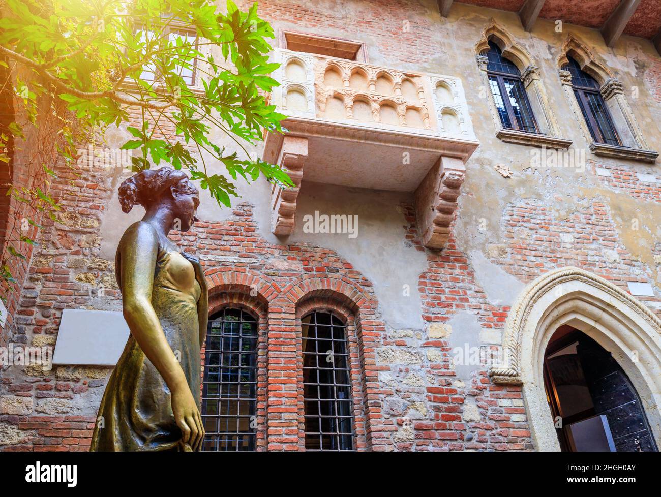 Verona, Italia. Estatua de bronce y balcón de la casa de Julieta. Foto de stock