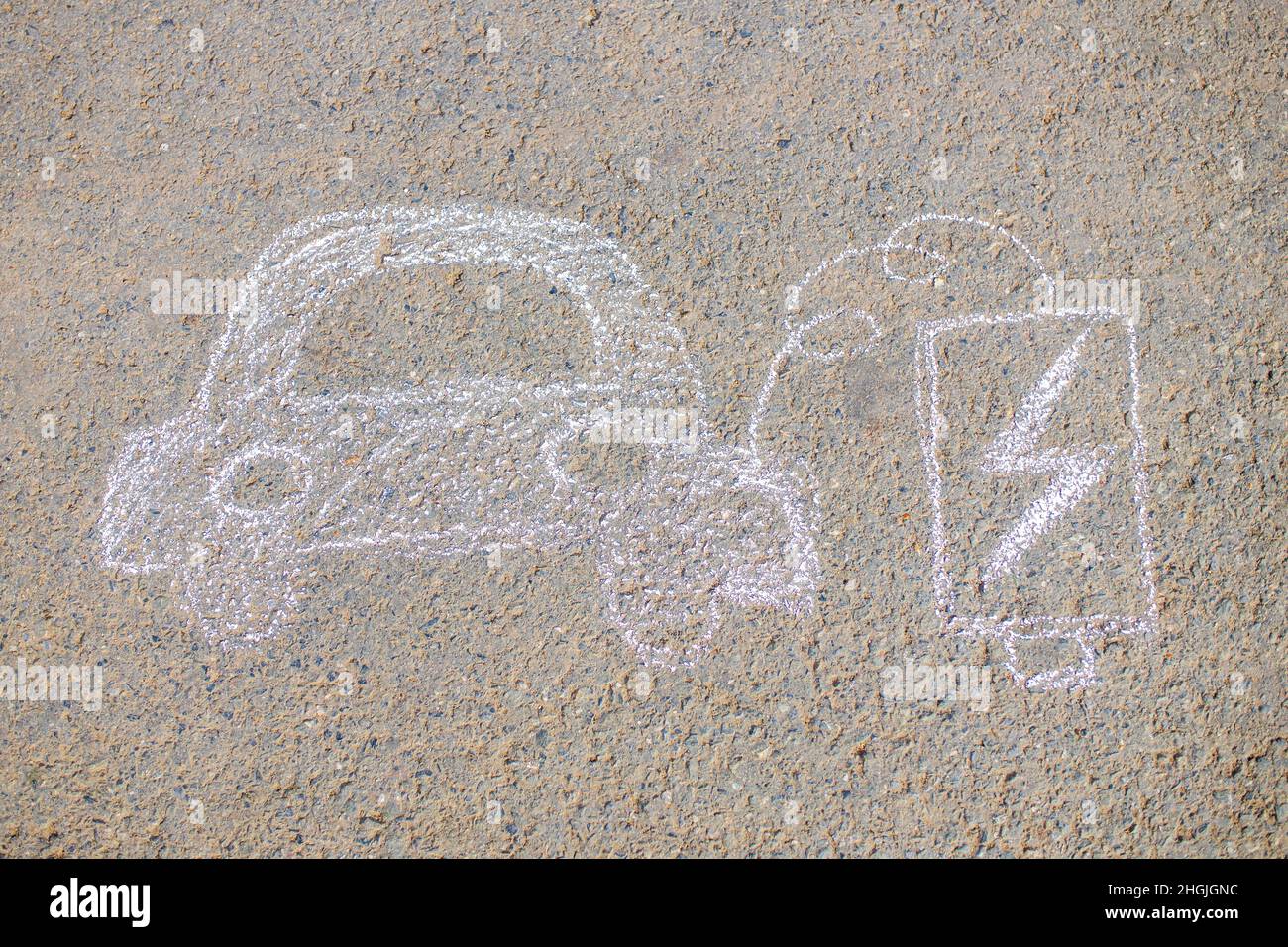 Niña con afición creativa artesanía que dibuja electro en el asfalto con el entorno de coche de tiza, ecológico, ahorrar energía en el parque en el día de verano Foto de stock