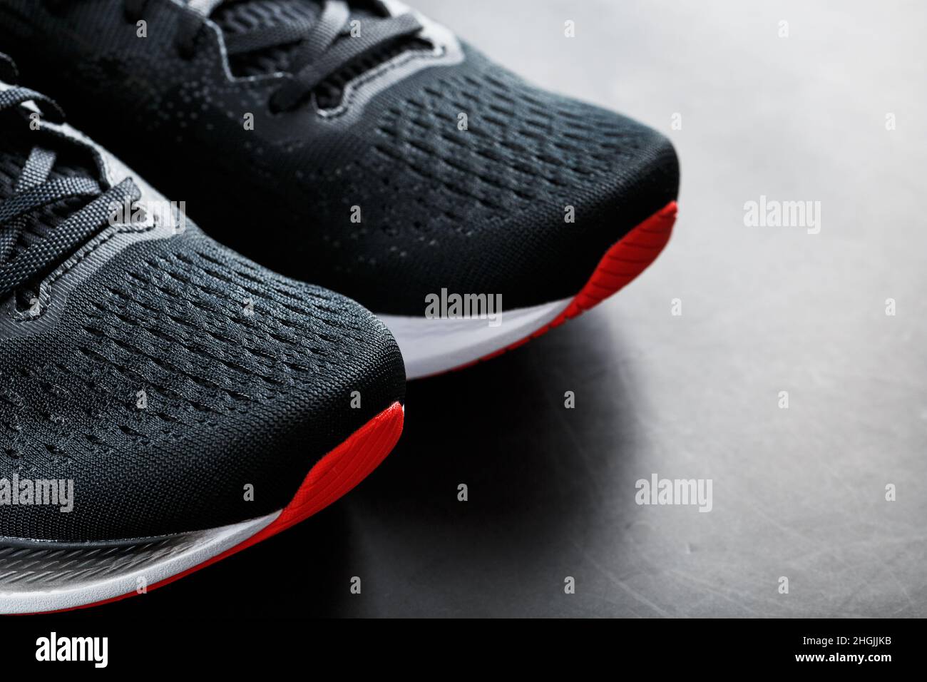 Zapatillas deportivas negras con suela roja sobre fondo negro. Espacio  libre Fotografía de stock - Alamy