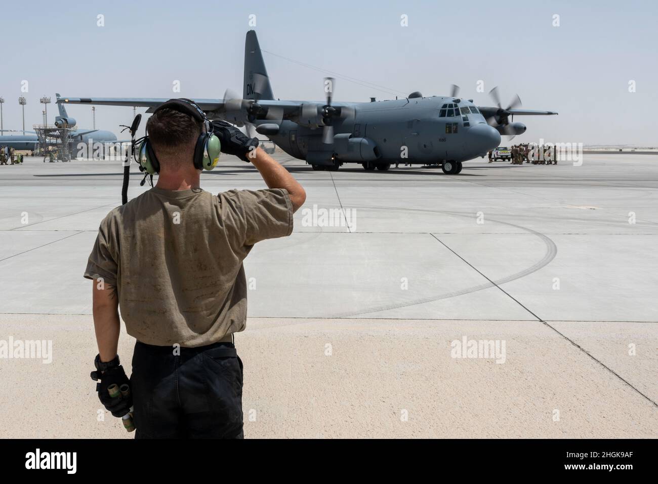 Un avión de la Fuerza Aérea de los Estados Unidos, con el escuadrón de mantenimiento de aeronaves expedicionarias de 380th, saluda a un avión de llamada de brújula EC-130H mientras se prepara para despegar de la Base Aérea de Al Dhafra, Emiratos Árabes Unidos, en apoyo de la evacuación no combatiente, agosto de 30 2021. El Departamento de Defensa está comprometido a apoyar la evacuación de ciudadanos estadounidenses, solicitantes especiales de visa de inmigrante y otras personas en riesgo de Afganistán. Foto de stock