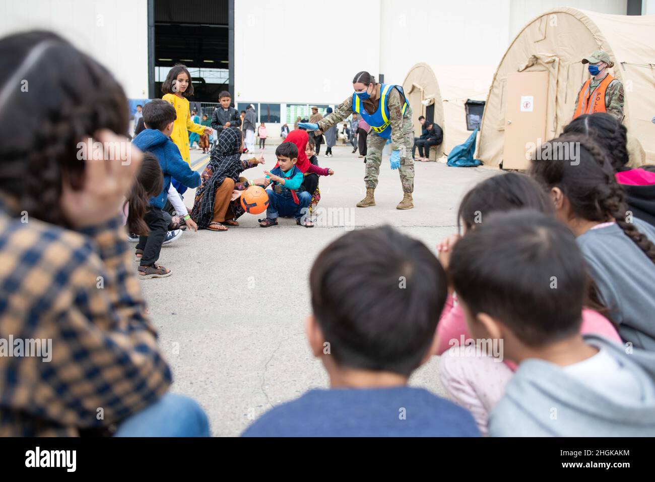 .S. Airman Meghan Ballard, jefe de la Fuerza Aérea, supervisor de 423rd pases y registro de las Fuerzas Aéreas asignadas a la Real Fuerza Aérea de Alconbury, Inglaterra, juega un partido con los niños durante la Operación Refugio Aliados en la Base Aérea de Ramstein, Alemania, 31 de agosto de 2021. Ramstein se transformó en el principal centro de evacuación del Comando Europeo de Estados Unidos, apoyando una de las operaciones de transporte aéreo humanitario más grandes y complejas de la historia. La Base Aérea de Ramstein se transformó en el principal centro de evacuación del Comando Europeo de los Estados Unidos, apoyando una de las operaciones de transporte aéreo humanitario más grandes y complejas de la historia. Foto de stock