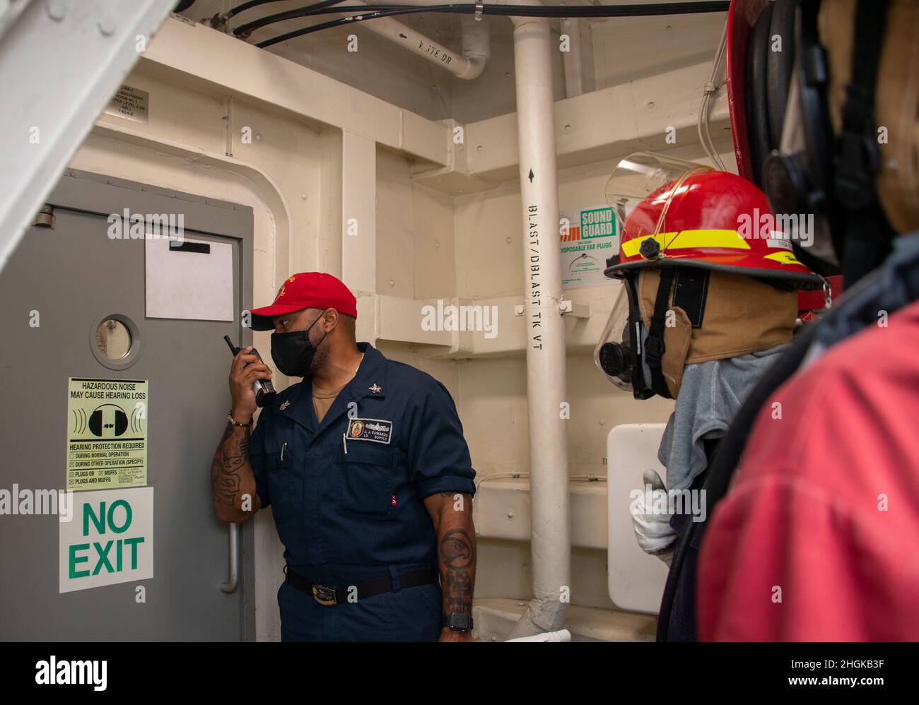 OCÉANO PACÍFICO (31 de agosto de 2021) — Especialista en Logística 1st Clase Jeremiah Edwards, a la izquierda, entrena a los marineros para investigar el acceso a la sala principal de motores durante el simulacro de incendio a bordo del buque anfibio de transporte USS Portland (LPD 27), agosto de 31. Portland, parte del USS Essex Amphibious Ready Group (ARG), junto con la Unidad Expedicionaria Marina (MEU) de 11th, Está operando en el área de responsabilidad de la Flota 7th de Estados Unidos para mejorar la interoperabilidad con aliados y socios y servir como una fuerza de respuesta lista para defender la paz y la estabilidad en la región del Indo-Pacífico. Foto de stock