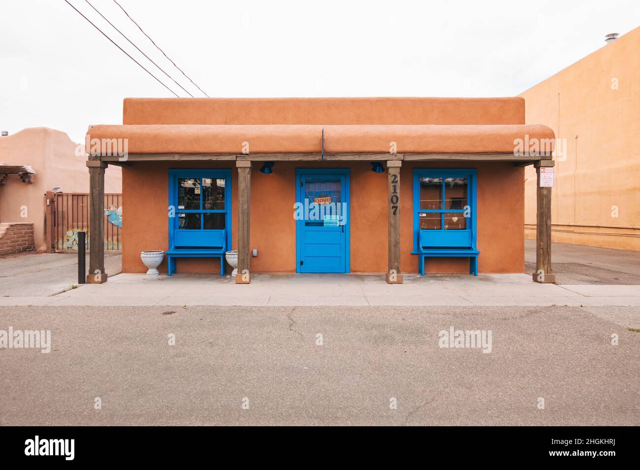 Un pequeño edificio de adobe con puertas y ventanas de color azul brillante en el casco antiguo de Albuquerque, Nuevo México Foto de stock