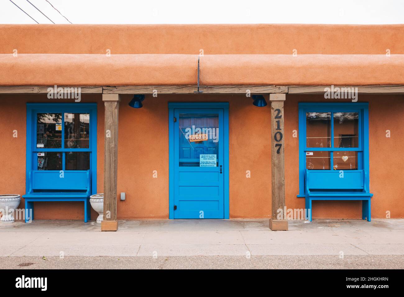 Un pequeño edificio de adobe con puertas y ventanas de color azul brillante en el casco antiguo de Albuquerque, Nuevo México Foto de stock