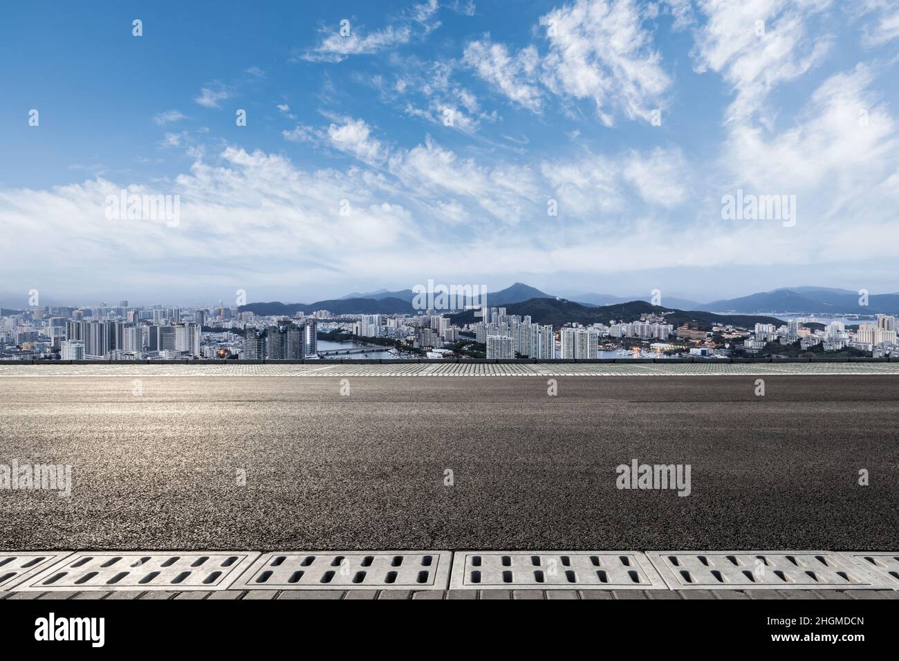 Carretera asfaltada y horizonte urbano moderno con edificios Foto de stock