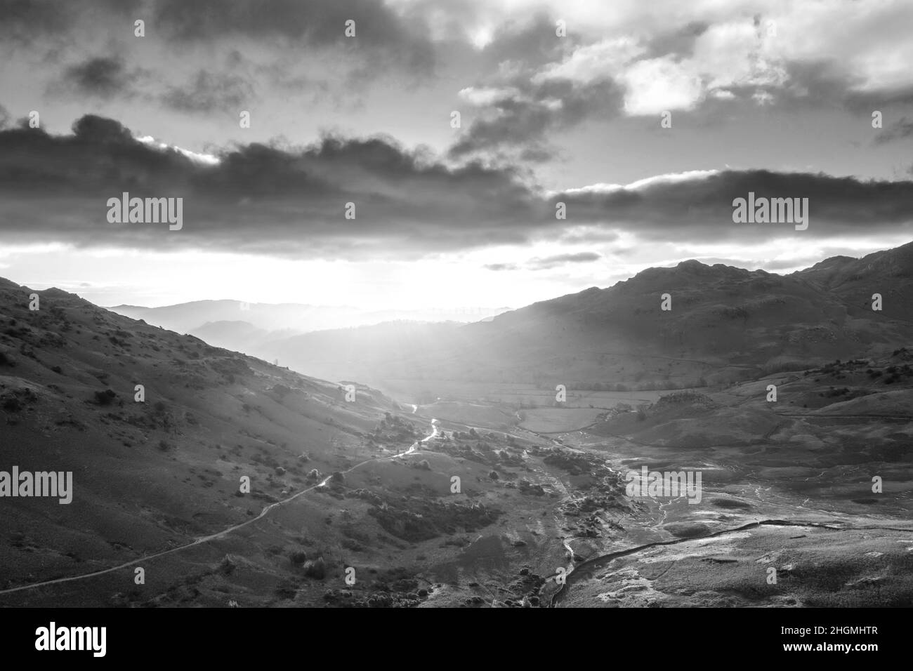 Blanco y negro Epic aérea drone paisaje imagen de la salida del sol desde Bea Tarn en Lake District durante impresionante exposición de otoño Foto de stock