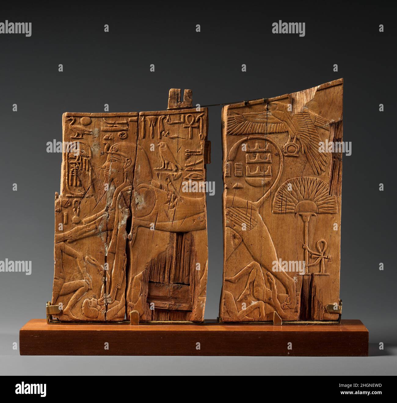 Panel de Brazo de una Cátedra Ceremonial de Thutmosis IV ca. 1400–1390 A.C. Imperio Nuevo Este panel de madera es parte del brazo izquierdo de un trono que pertenecía al faraón Thutmosis IV Los rastros de pegamento en la superficie sugieren que el bajo relieve, con sus detalles exquisitamente tallados, fue una vez cubierto con papel de aluminio dorado. Por un lado, el rey se muestra como una esfinge de pie que sojuzga a los enemigos de Egipto. El halcón en la parte superior derecha representa al dios Horus que es identificado como 'el gran dios, con plumaje endulzado, dando vida y dominio'. El texto sobre la espalda de la esfinge dice: 'Horus, el señor de la fuerza y a. Foto de stock