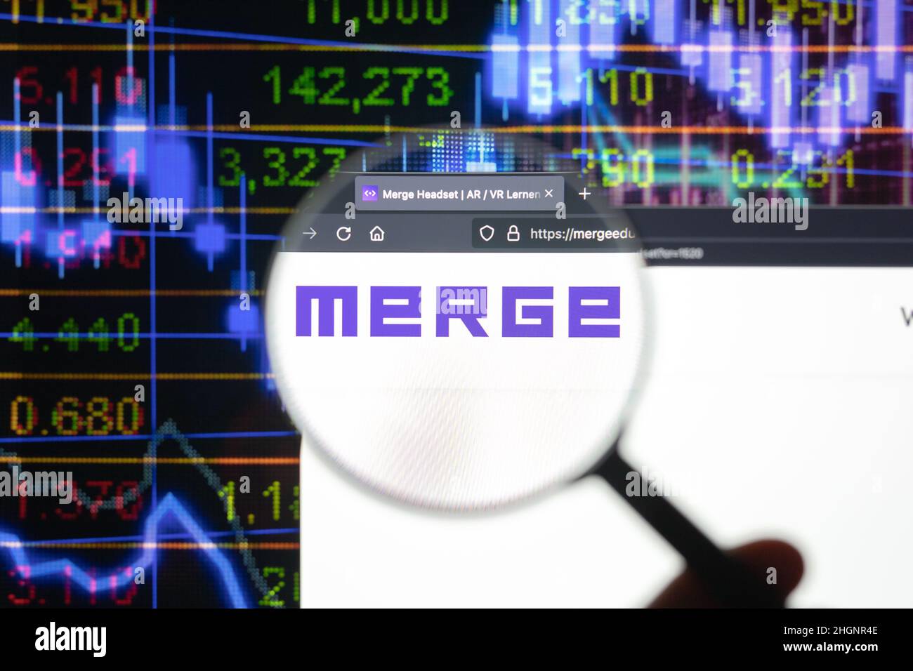 Fusione el logotipo de la empresa en un sitio web con la evolución borrosa del mercado de valores en segundo plano, visto en una pantalla de ordenador a través de una lupa. Foto de stock