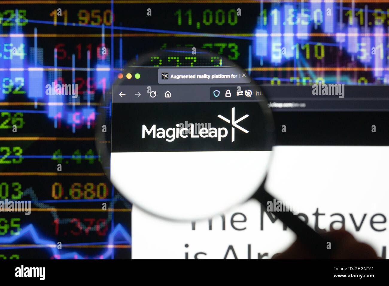Magic Leap logotipo de la empresa en un sitio web con la borrosa evolución del mercado de valores en el fondo, visto en una pantalla de ordenador a través de una lupa. Foto de stock