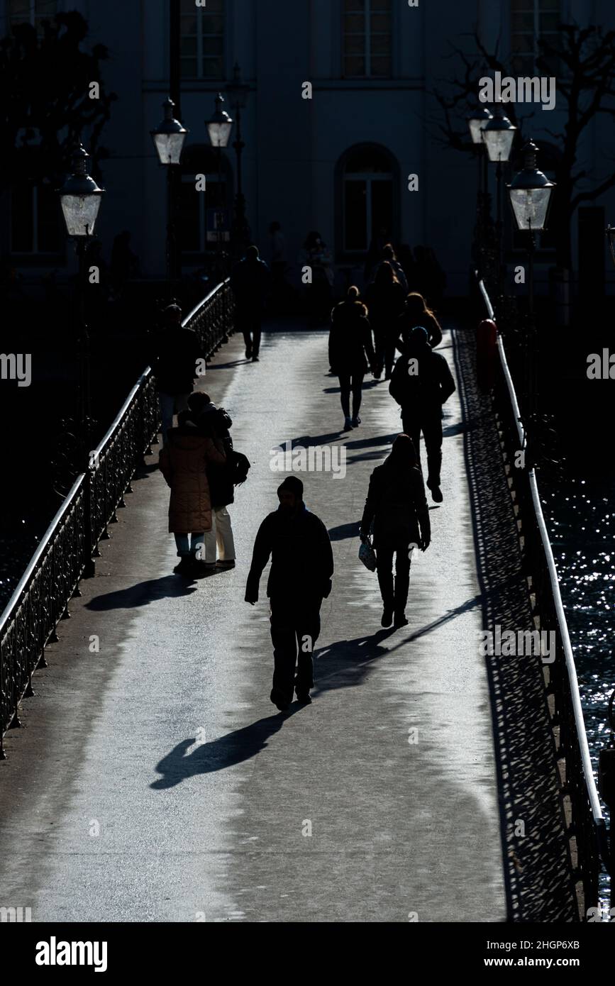 Vista en formato retrato de peatones en un puente en silueta, Lucerna, Suiza. Foto de stock
