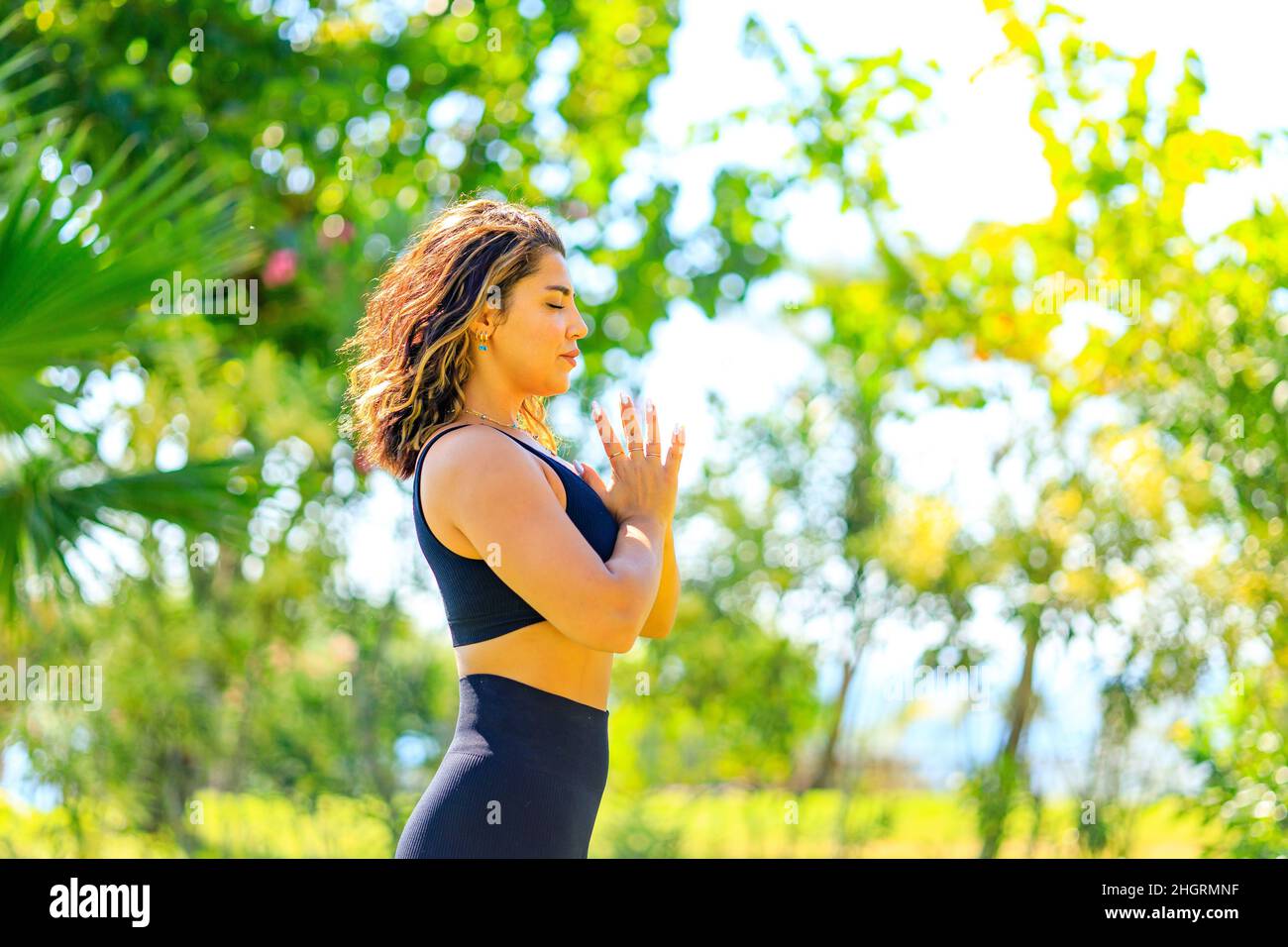 Joven india atractiva mujer que practica yoga , respiración profunda y tranquila al aire libre en el parque verde de verano Foto de stock