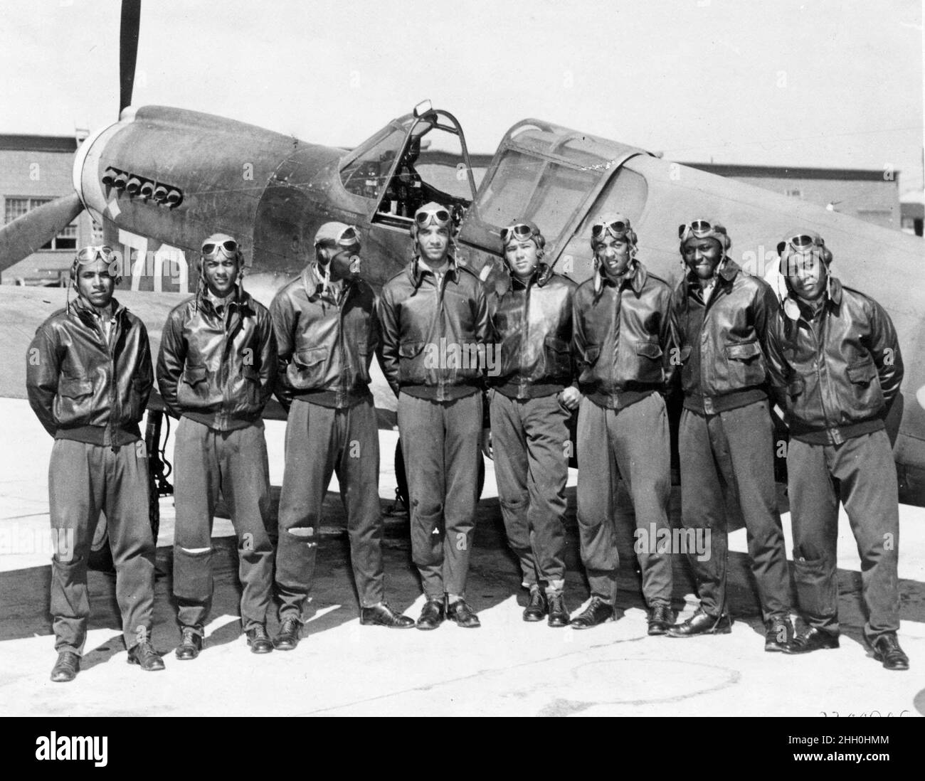 Un grupo de los aviadores Tuskeegee en un aeródromo por un avión Tomahawk Curtiss P-40 Foto de stock