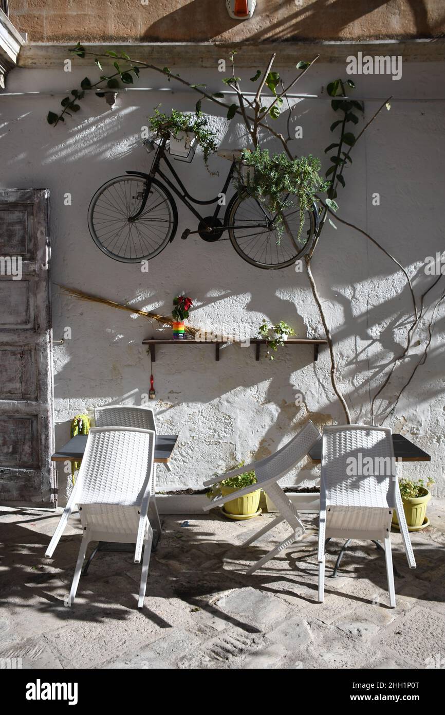 Una bicicleta colgada en una pared fuera de un bar con una silla