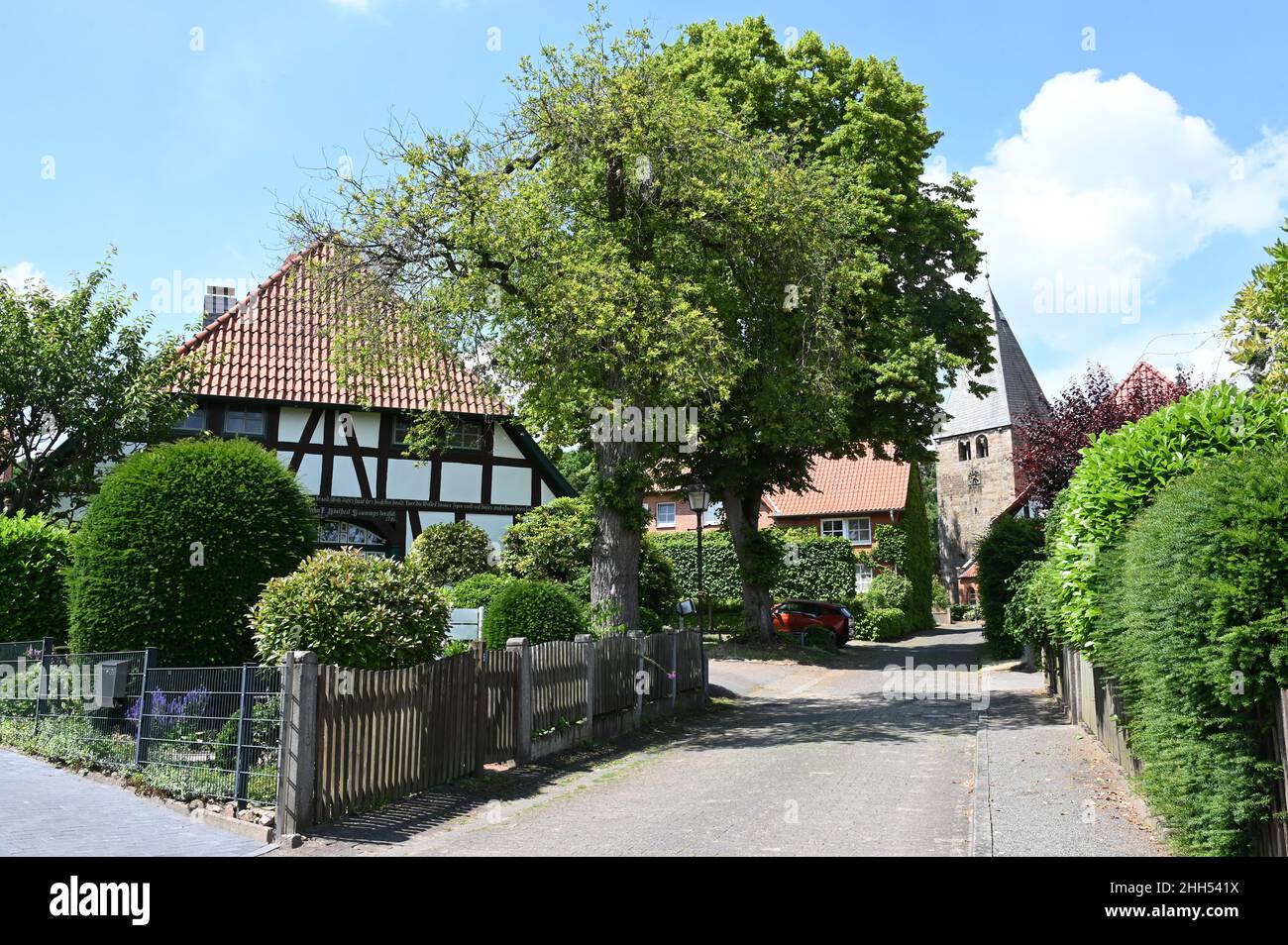 Marklohe: Vista idílica del pueblo con una casa de entramado de madera y una iglesia medieval Foto de stock