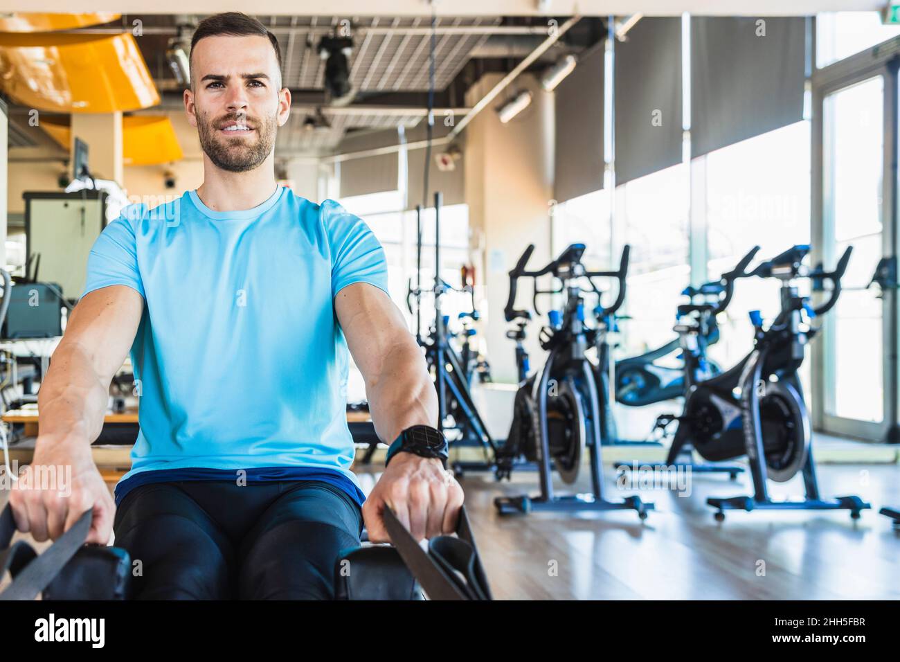 Deportista con equipo de ejercicio en el gimnasio Foto de stock