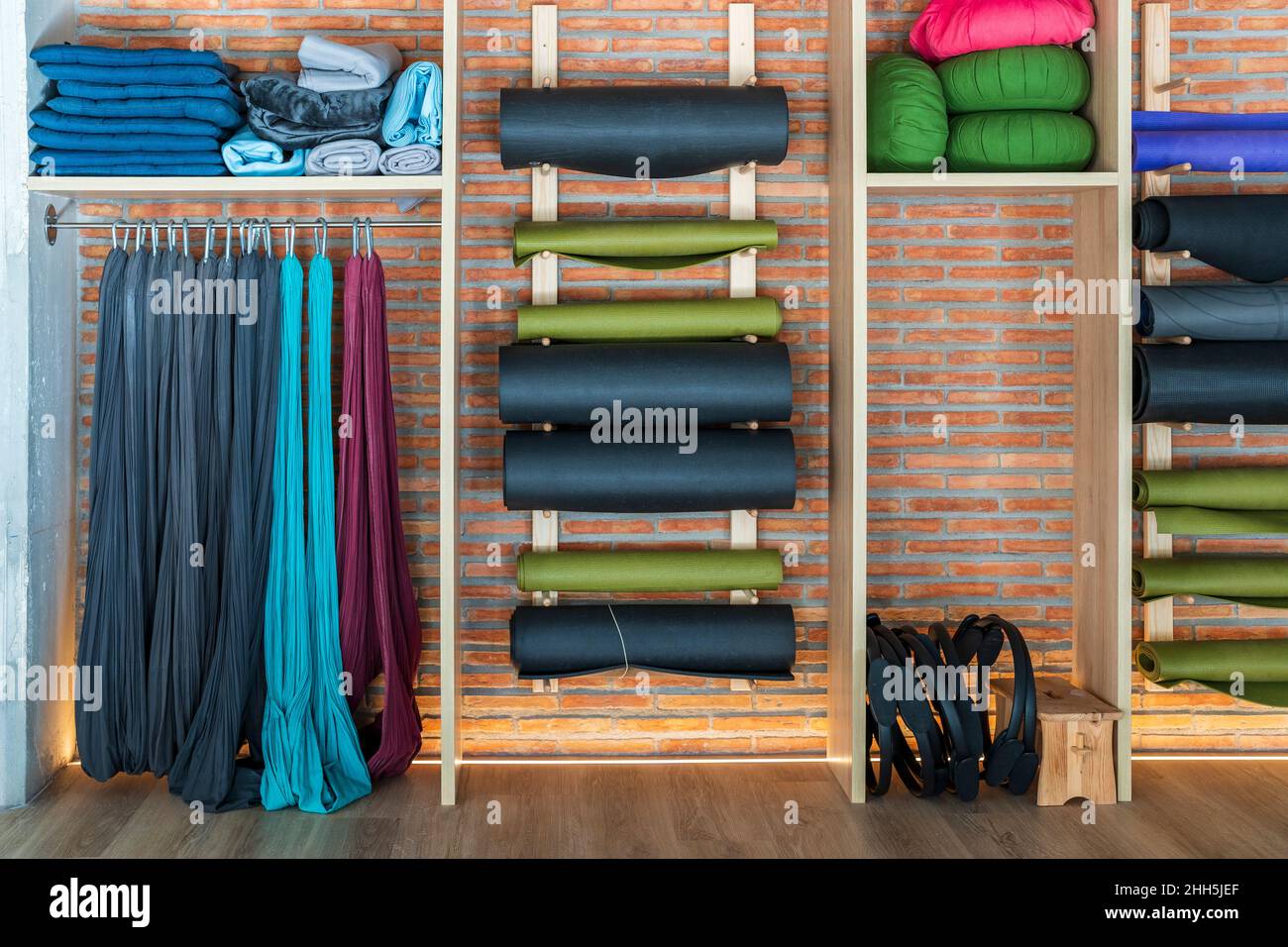 Equipo de ejercicio organizado en un estante en el estudio de yoga Foto de stock