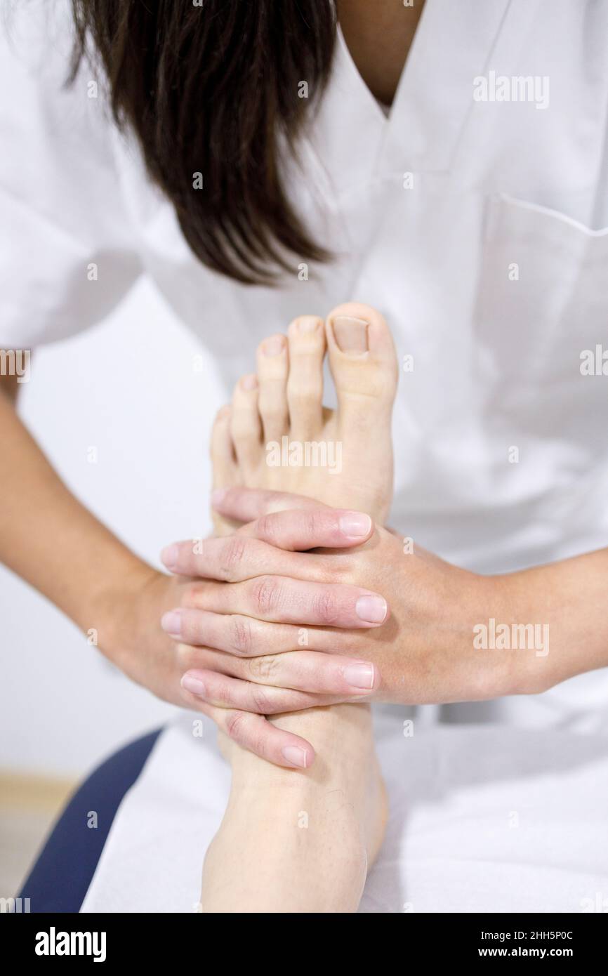 Fisioterapeuta masajeando el pie de atleta en un centro de rehabilitación Foto de stock